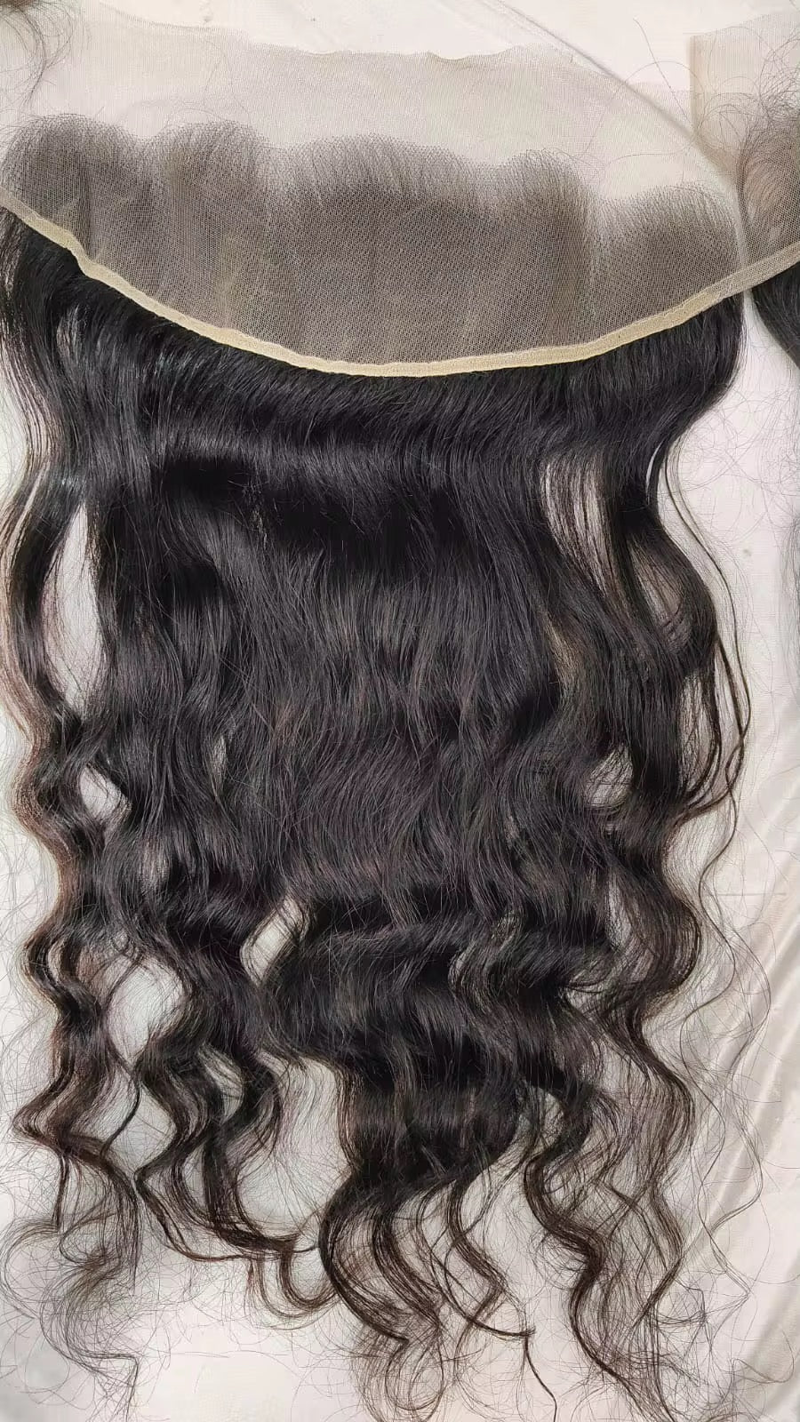 Black wavy hair lace frontal closure with a natural-looking hairline on a white background.