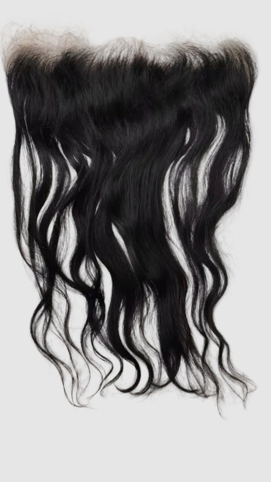 Black wavy hair lace frontal extension piece laid flat on a white satin fabric background.