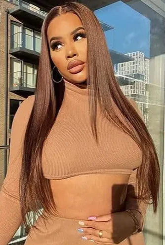 Woman wearing a brown outfit with a cityscape background